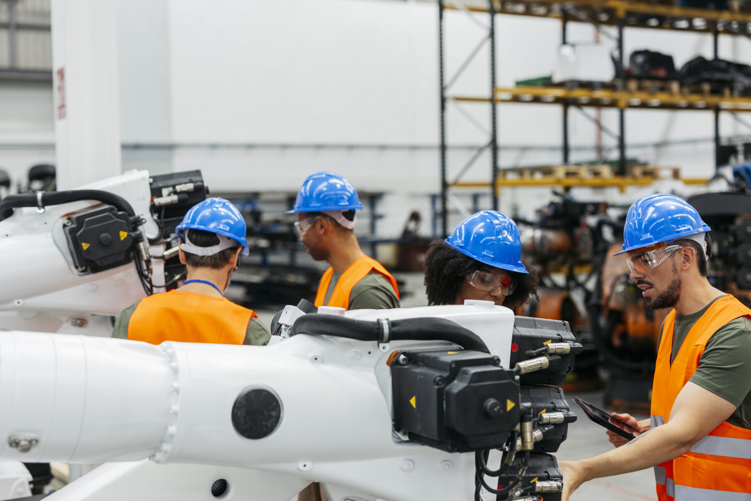 Engineers maintaining robotic arm in modern factory